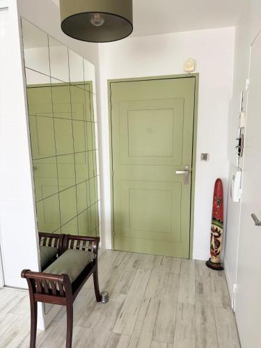 a room with a bench and a green door at LA PROVENCE fantastic apartment 75m2 Big pool private parking top location in Le Pontet