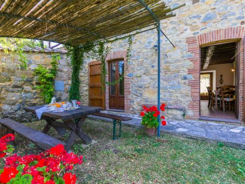 a stone house with a picnic table in the yard at Apartment Stalla by Interhome in Sasso Pisano