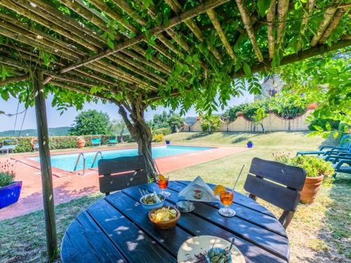 a blue table under a pergola next to a pool at Apartment Stalla by Interhome in Sasso Pisano