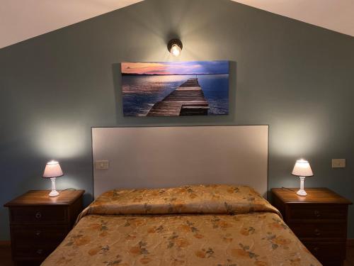 a bedroom with a bed and two night stands with lamps at Agriturismo Tenuta Badia in Paciano