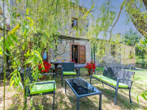 a group of chairs and tables in a yard at Apartment Stalla by Interhome in Sasso Pisano