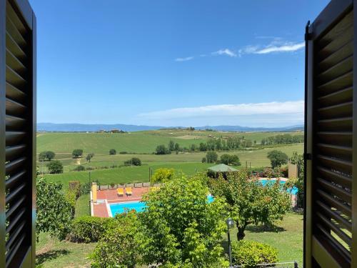 a view of a resort with a swimming pool and fields at Agriturismo Tenuta Badia in Paciano