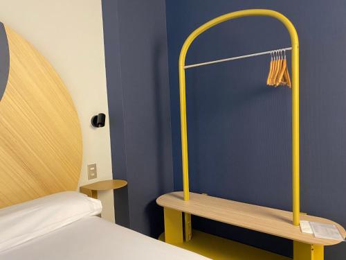 a bedroom with a bed and a bench with a hanger at Onix Fira in Barcelona