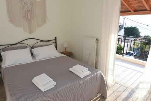 a bedroom with a bed with two towels on it at Denaxas Apartments in Elia Laconias