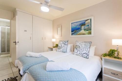 a bedroom with two beds with blue sheets at Ocean Pearl at Chakas Cove - Beachfront Apartment in Ballito