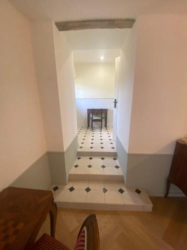 a hallway with a table and a chair in a room at Domaine hotel de France in Cunfin