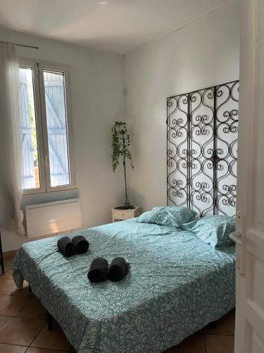 - une chambre avec un lit et 2 chaussons noirs dans l'établissement LE BONHEUR AVEC PISCINE ET JARDIN, à Cassis
