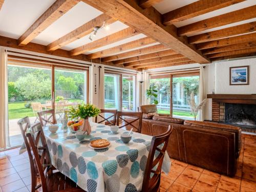 une salle à manger avec une table et des chaises et une cheminée dans l'établissement Holiday Home Roitelet by Interhome, à Mimizan-Plage
