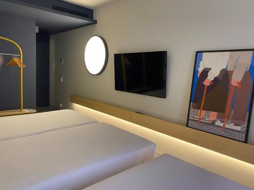 a room with a bed and a tv on a wall at Onix Fira in Barcelona