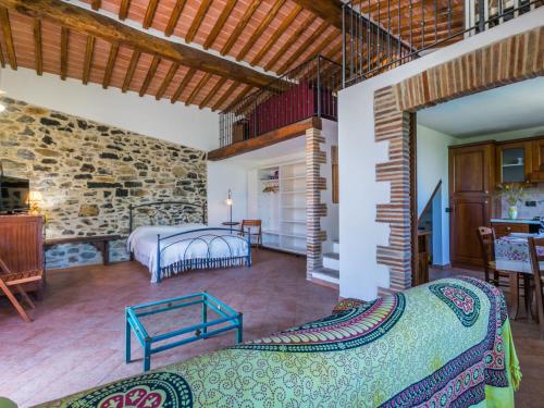 a room with two beds and a stone wall at Apartment Fienile by Interhome in Sasso Pisano