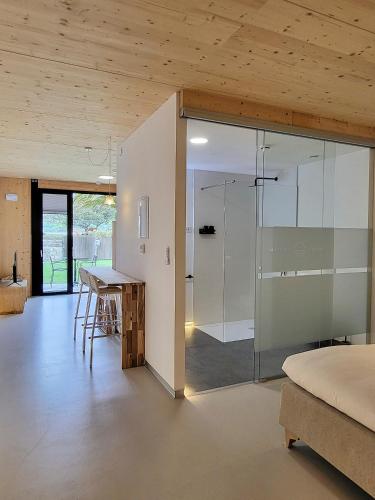 a bedroom with a glass shower and a table at Maison Laida in Ibarrangelu
