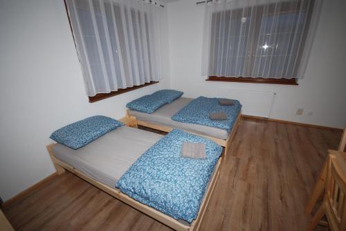 two beds in a room with wooden floors and windows at Noclegi Dywity in Dywity
