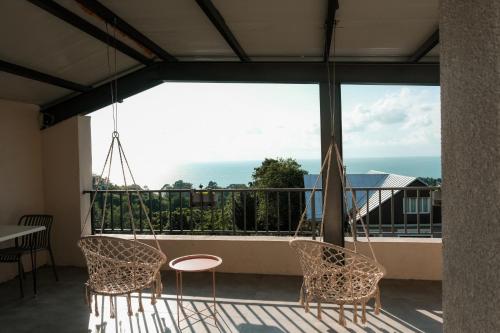 a balcony with two chairs and a swing at Limonura in Tsikhisdziri