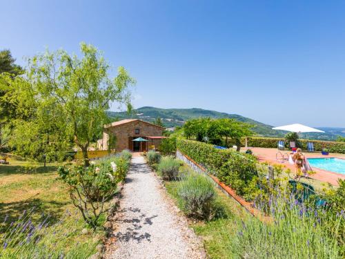 a garden with a house and a swimming pool at Apartment Fienile by Interhome in Sasso Pisano