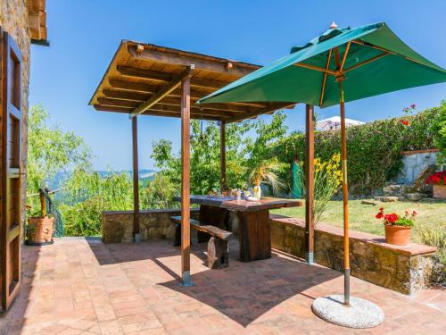 a patio with a table and an umbrella at Apartment Fienile by Interhome in Sasso Pisano