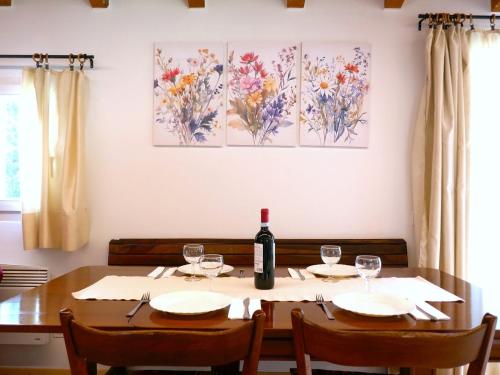 a dining room table with a bottle of wine on it at Holiday Home Felice by Interhome in Anvéuda