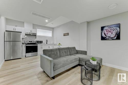 a living room with a couch and a kitchen at Cozy Up in Edmonton