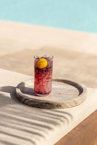 a drink with an orange on a wooden coaster at Ela Tinos in Arnados