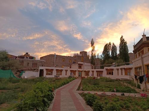 a building with a walkway in front of a courtyard at The Kurja Garden in Leh