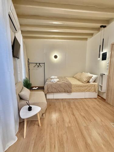 a bedroom with a bed and a couch and a table at Lumière Carmela in Corfu