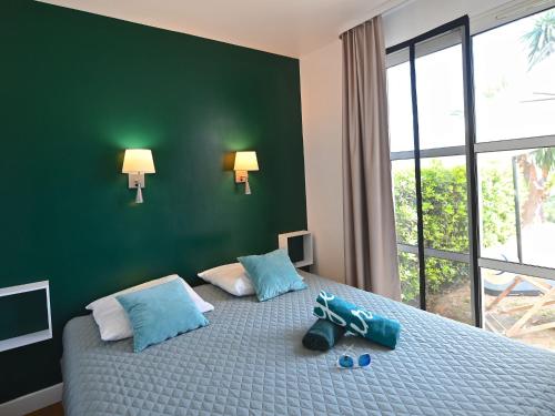 une chambre avec un lit avec deux chaussures dessus dans l'établissement Apartment Le Village - C2 004 by Interhome, à Agay