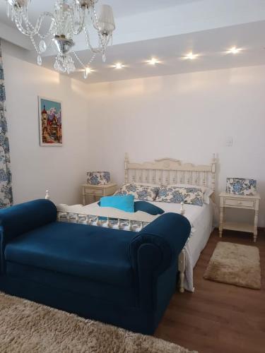 a bedroom with a bed and a blue couch at Suítes na montanha in Águas de Lindóia