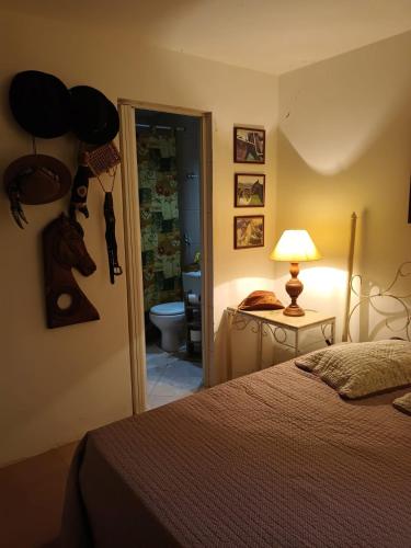a bedroom with a bed and a door to a bathroom at Suítes na montanha in Águas de Lindóia