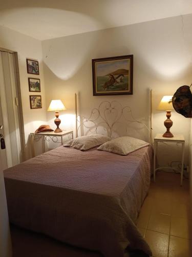 a bedroom with a bed and two lamps on two tables at Suítes na montanha in Águas de Lindóia