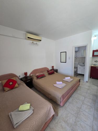 two beds sitting in a room with a kitchen at Kostic Apartments in Buljarica
