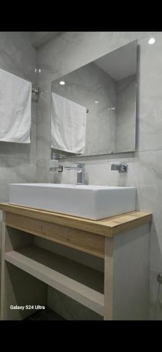 a bathroom with a large white tub and a mirror at Kos Cozy Home in Kos