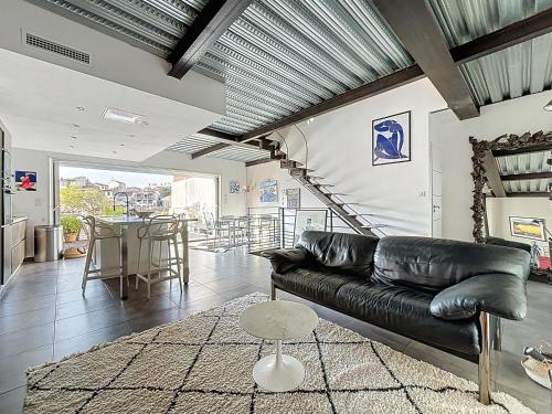 un salon avec un canapé en cuir et une table dans l'établissement Maison charmante - Vue sur Notre Dame - Les Frères de la loc', à Marseille