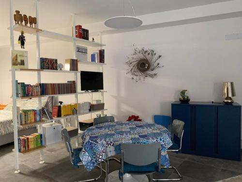 ein Esszimmer mit einem Tisch und einem Bücherregal in der Unterkunft Loft di Gianluca e Grazia in Maracalagonis