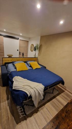 a bedroom with a large blue bed with yellow pillows at LE MUGEL cocooning SPA et proche calanques de Cassis in Carnoux
