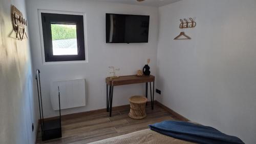 a room with a bed and a table and a television at LE MUGEL cocooning SPA et proche calanques de Cassis in Carnoux