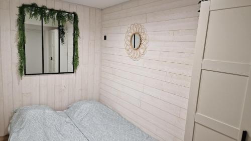 a bedroom with white walls and a mirror and a bed at LE MUGEL cocooning SPA et proche calanques de Cassis in Carnoux