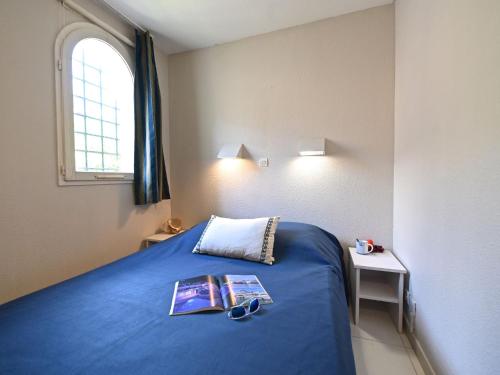 - une chambre dotée d'un lit avec un livre et des verres dans l'établissement Apartment Le Village - VJ106 by Interhome, à Saint-Raphaël