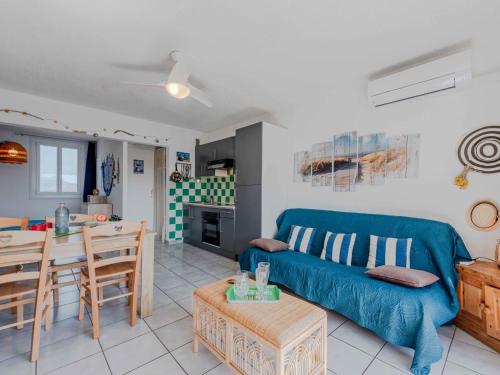 un salon avec un canapé bleu et une table dans l'établissement Apartment Palmyra-1 by Interhome, au Barcarès