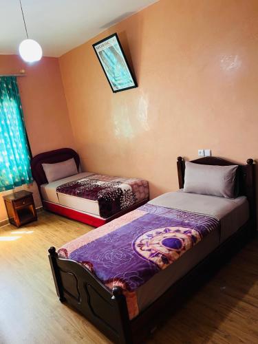 a bedroom with two beds and a window at Hagounia hotel in Tan-Tan