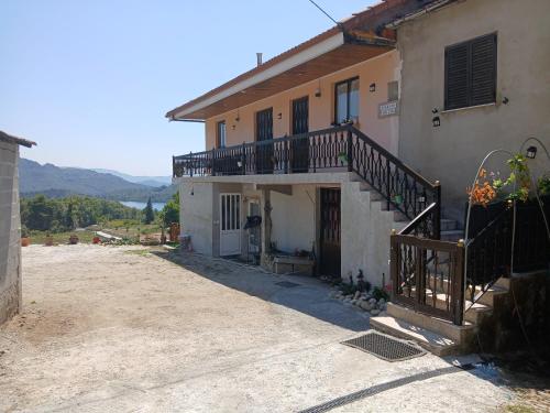 a house with a balcony on the side of it at Casa da Emilia do Gerês in Outeiro
