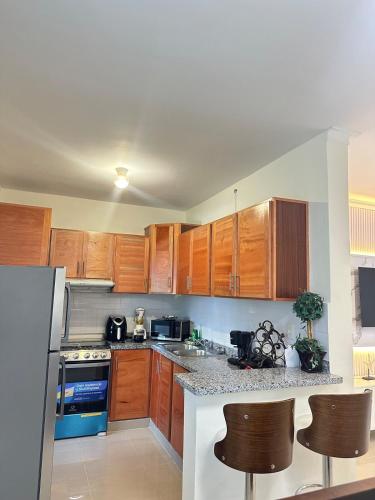 a kitchen with wooden cabinets and a counter top at Vista Azul Boca Chica Accommodation in El Higo
