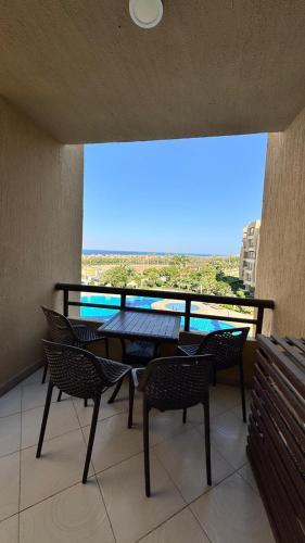 a balcony with a table and chairs and a large window at Grand Ocean El Sokhna in Ain Sokhna