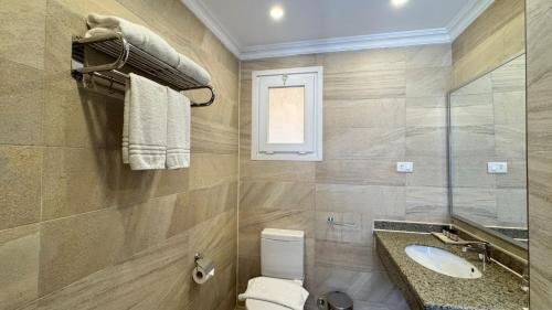 a bathroom with a toilet and a sink and a window at Grand Ocean El Sokhna in Ain Sokhna