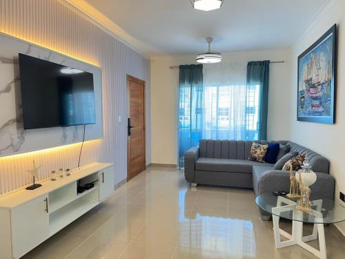 a living room with a couch and a tv at Vista Azul Boca Chica Accommodation in El Higo