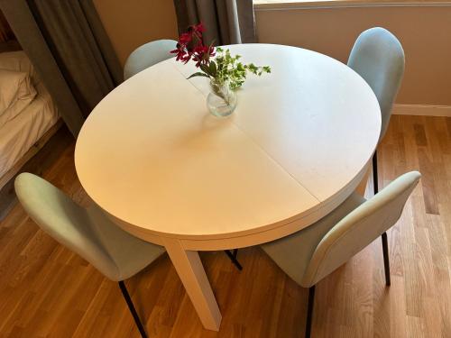 a white table with chairs and a vase with flowers at La Casa Klippan in Rockneby