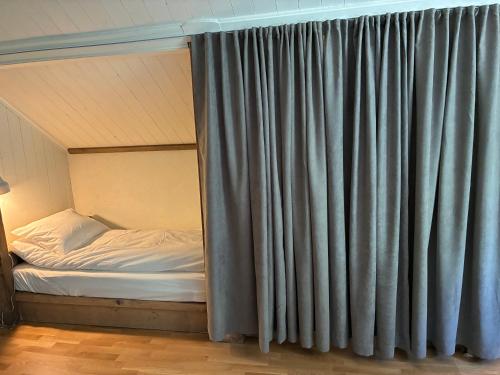 a bed in a room with a curtain at La Casa Klippan in Rockneby