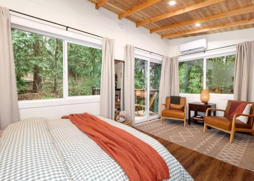 Un dormitorio con una cama grande y ventanas. en Relaxing Tree House in Sequim, Washington, Perfect for a Glamping Getaway to Olympic National Park, en Sequim
