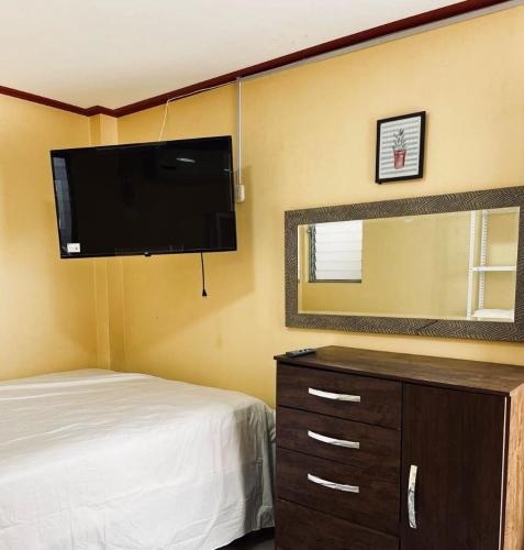 a bedroom with a bed and a flat screen tv at Departamento Céntrico in Pucallpa