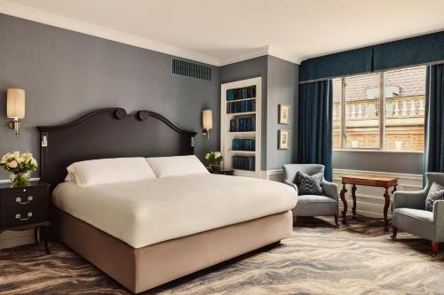 a bedroom with a large white bed and a chair at The Connaught, Maybourne in London