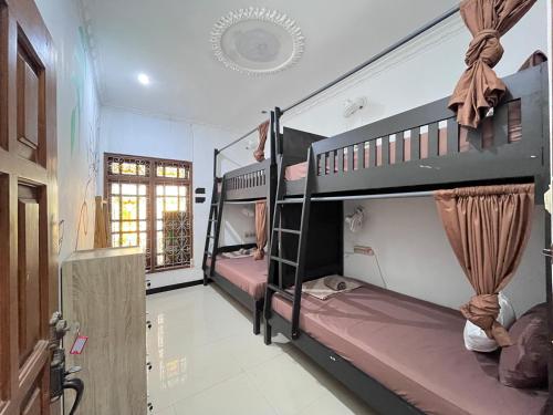 a room with two bunk beds and a window at Bromo Breeze by Zzz in Malang