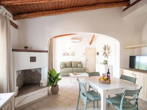 a living room with a white table and chairs and a fireplace at Apartment Palau by Interhome in Arzachena